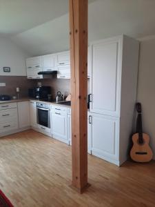 a kitchen with white cabinets and a wooden pole at Apartmán Mikulov in Mikulov