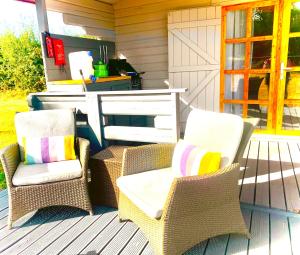 twee stoelen en een tafel op een veranda bij La Papillon Glamping in La Châtre