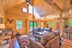 a living room with a couch and a table at Wooded North Haverhill Haven with Wood Fire Pit 