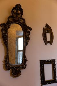 an ornate mirror on a wall with two mirrors at Maison Flipot in Torre Pellice