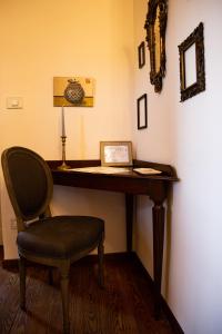 einen Schreibtisch mit einem Stuhl und einem Bild darauf in der Unterkunft Maison Flipot in Torre Pellice
