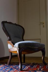Una silla blanca y negra sentada sobre una alfombra. en Maison Flipot, en Torre Pellice