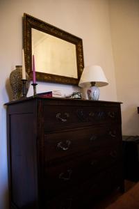 a dresser with a lamp and a mirror on it at Maison Flipot in Torre Pellice