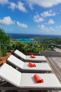 three lounge chairs on a deck with a view of the ocean at Villa La Vue - Vue panoramique sur les lagons in Gustavia