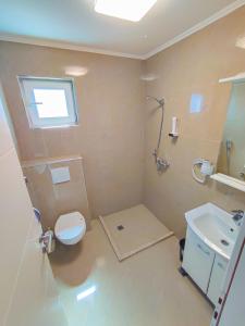 a bathroom with a toilet and a sink at Oaza Mira Hotel & Resort-فندق ومنتجع واحة الهدوء in Vlasic