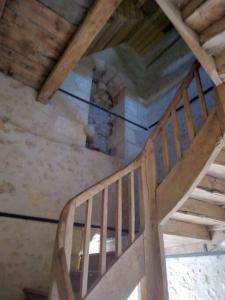 a wooden staircase in a room with a ceiling at Le Manoir à proximité de Tours in Chanceaux-sur-Choisille