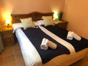 a large bed with black and white sheets and pillows at IMEDA APARTAMENTO ENEBRO in Sierra Nevada