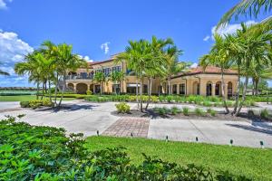 a large house with palm trees in front of it at Bonita Springs Condo with Lake and Golf Views! in Bonita Springs