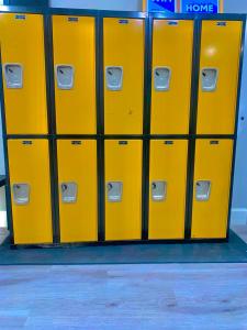 a row of yellow lockers in a locker room at STOP Inn STAY HOSTEL in Houston