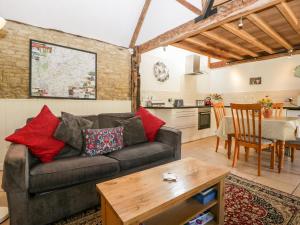 a living room with a couch and a table at Tump Cottage in Nympsfield