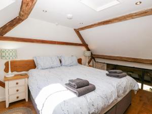 a bedroom with a bed with towels on it at Tump Cottage in Nympsfield