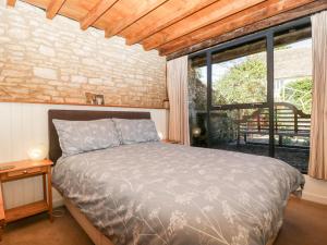 ein Schlafzimmer mit einem Bett und einem großen Fenster in der Unterkunft Nympy Cottage in Nymphsfield
