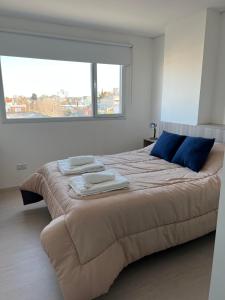 a bedroom with a large bed with towels on it at APART trelew 5 in Trelew