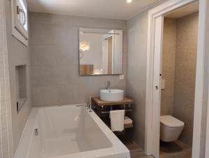 a bathroom with a tub and a sink and a toilet at Casas Natura Suites in Graus