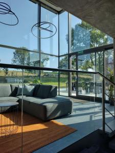 a living room with a couch and a large window at The Kettle House - Manor in Sint-Pieters-Leeuw