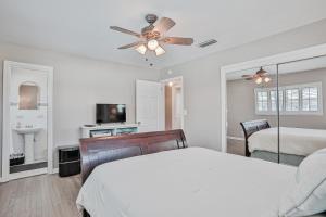 una camera da letto con un letto e un ventilatore a soffitto di Beach house & backyard oasis with private pool - short walk to beach a Baptist Medical Center/Beaches Heliport Altre 28 foto