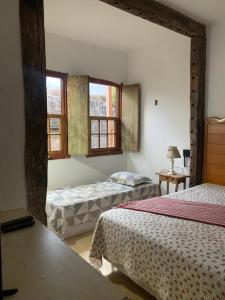1 dormitorio con 2 camas y 2 ventanas en Chalé das Flores, en Tiradentes