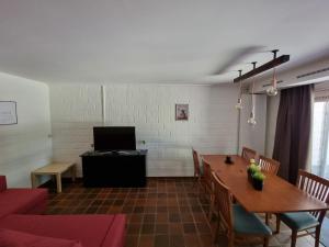 a living room with a table and a tv at Gezellig appartement in groene omgeving in Drijhoeven