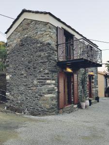 un edificio de piedra con un balcón en un lateral. en dolihis gi "loupastra"kampos ikaria, en Evdilos