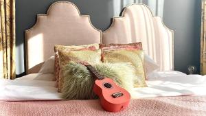 eine rote Gitarre auf einem Bett mit Kissen in der Unterkunft City Solei Boutique Hotel in Posen
