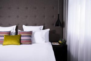 a bed with a white comforter and pillows at K West Hotel & Spa in London