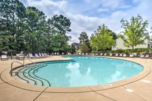 uma grande piscina com cadeiras e árvores em Spacious Cary Retreat with Patio and Pool Access! em Cary