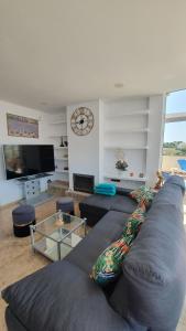 Una sala de estar con un sofá y un reloj en la pared. en Green hills, en La Cala de Mijas