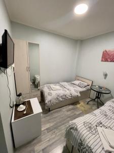 a bedroom with two beds and a table and a mirror at MR Guest House in Tbilisi City