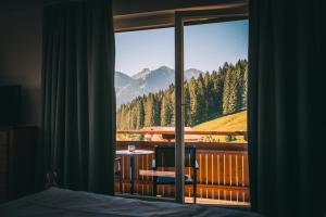 1 dormitorio con vistas a la montaña desde una ventana en Alpengasthof Hörnlepass en Riezlern
