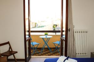 een kamer met een balkon met een tafel en stoelen bij Casa Rosetta in Lecce