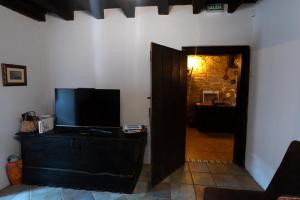 a living room with a television and a door to a hallway at Mujika Etxea in Manurga