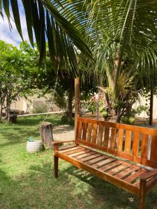 a wooden bench in a yard with a swing at Chácara aconchego do Valle in Petrolina