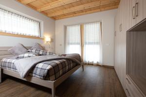 a bedroom with a bed and two windows at Bondi Chalet St Antoni in Livigno