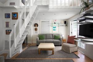 a living room with a couch and a staircase at Bahama Gardens - Turtle House in Key West