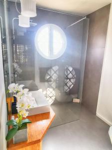 a bathroom with a glass shower with a table and a window at Leo San Bruno in Isla Canela