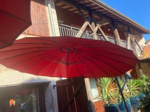 a red umbrella in front of a building at Chambres d hotes THE RESID in Pérouges