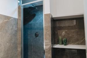 um chuveiro com uma porta de vidro na casa de banho em AURA em Terlizzi