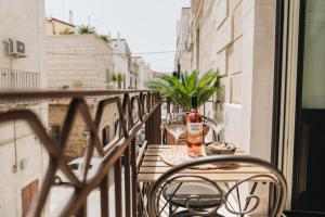 una mesa con una botella de vino en el balcón en AURA, en Terlizzi