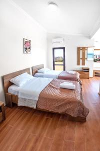 高尼奥Hotel Mandarinebi的卧室设有两张床,铺有木地板