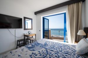a bedroom with a bed and a view of the ocean at Apartamentos Playa Feliz in Playa del Ingles