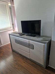 una TV a schermo piatto seduta sopra un comò di Apartament W2, Mieszkanie dla Wszystkich a Konin
