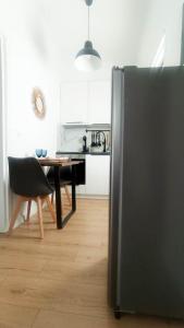 Il comprend une cuisine équipée d'un réfrigérateur et d'une table avec une chaise. dans l'établissement DOWN TOWN Luxurious Apartments (3), à Alexandroúpolis