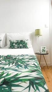 - un lit avec une couette verte et blanche et une table dans l'établissement DOWN TOWN Luxurious Apartments (3), à Alexandroúpolis