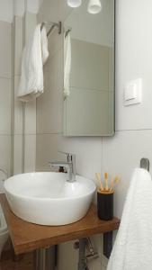 La salle de bains est pourvue d'un lavabo blanc et d'un miroir. dans l'établissement DOWN TOWN Luxurious Apartments (3), à Alexandroúpolis