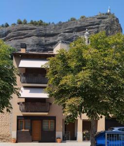 un bâtiment avec une montagne en arrière-plan dans l'établissement Casas Natura, à Graus