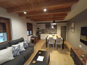 ein Wohnzimmer mit einem Sofa und einem Tisch in der Unterkunft Parada de Txambonet 2 in Vilaller