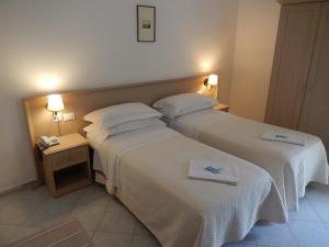 a hotel room with two beds and a telephone at Hotel Europa in Ischia