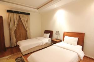 1 dormitorio con 2 camas y ventana en Towlan Hotel Suites 1, en Riad