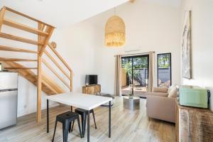 ein Wohnzimmer mit einem Tisch und einem Sofa in der Unterkunft CASA MAMALOSA & SPA in Andernos-les-Bains
