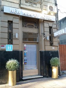 a hotel with two potted plants in front of the door at New Arapey Hotel in Montevideo